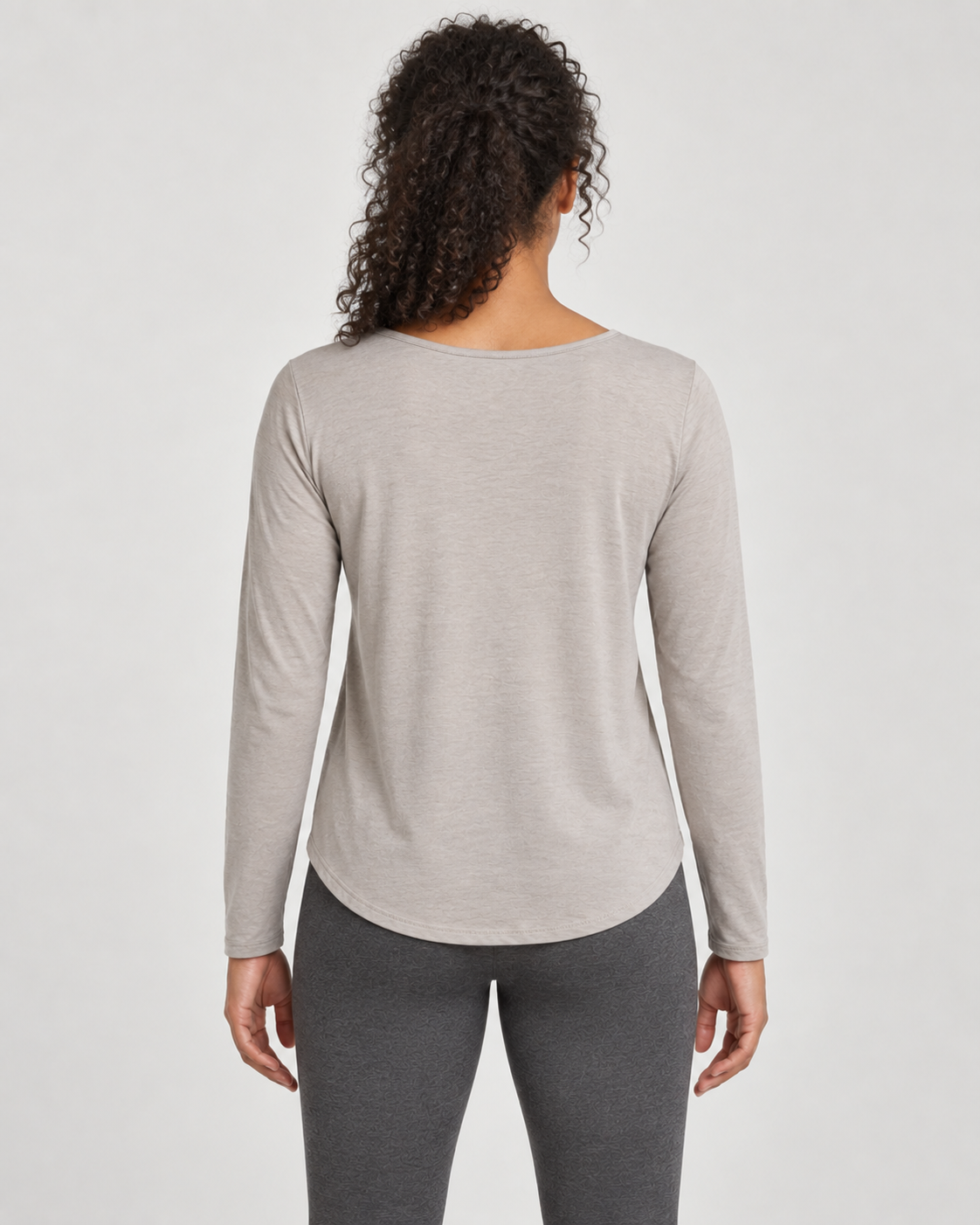 Concept mockup: Akumi Drift Scoop Long Sleeve in Stone, back view on an adult woman.