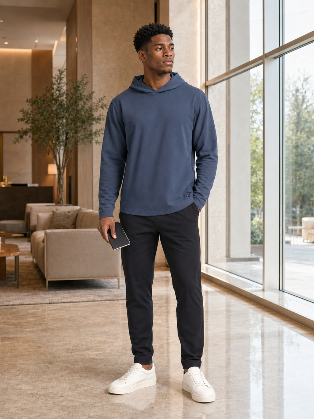 Akumi AeroLayer Travel Hoodie worn in a modern hotel lobby