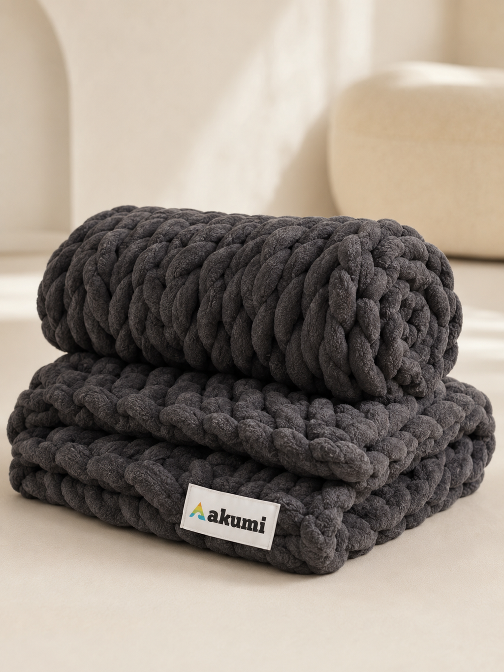 Akumi Anchor Blanket folded and rolled showing weighted loop texture and Akumi label