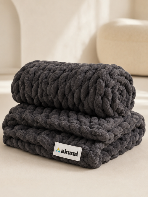 Akumi Anchor Blanket folded and rolled showing weighted loop texture and Akumi label