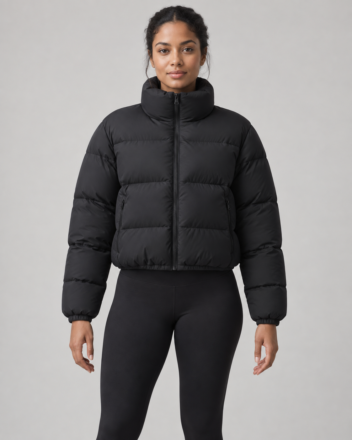 AI-generated design concept: Akumi Arc Cropped Puffer in Onyx, front view on an adult woman.