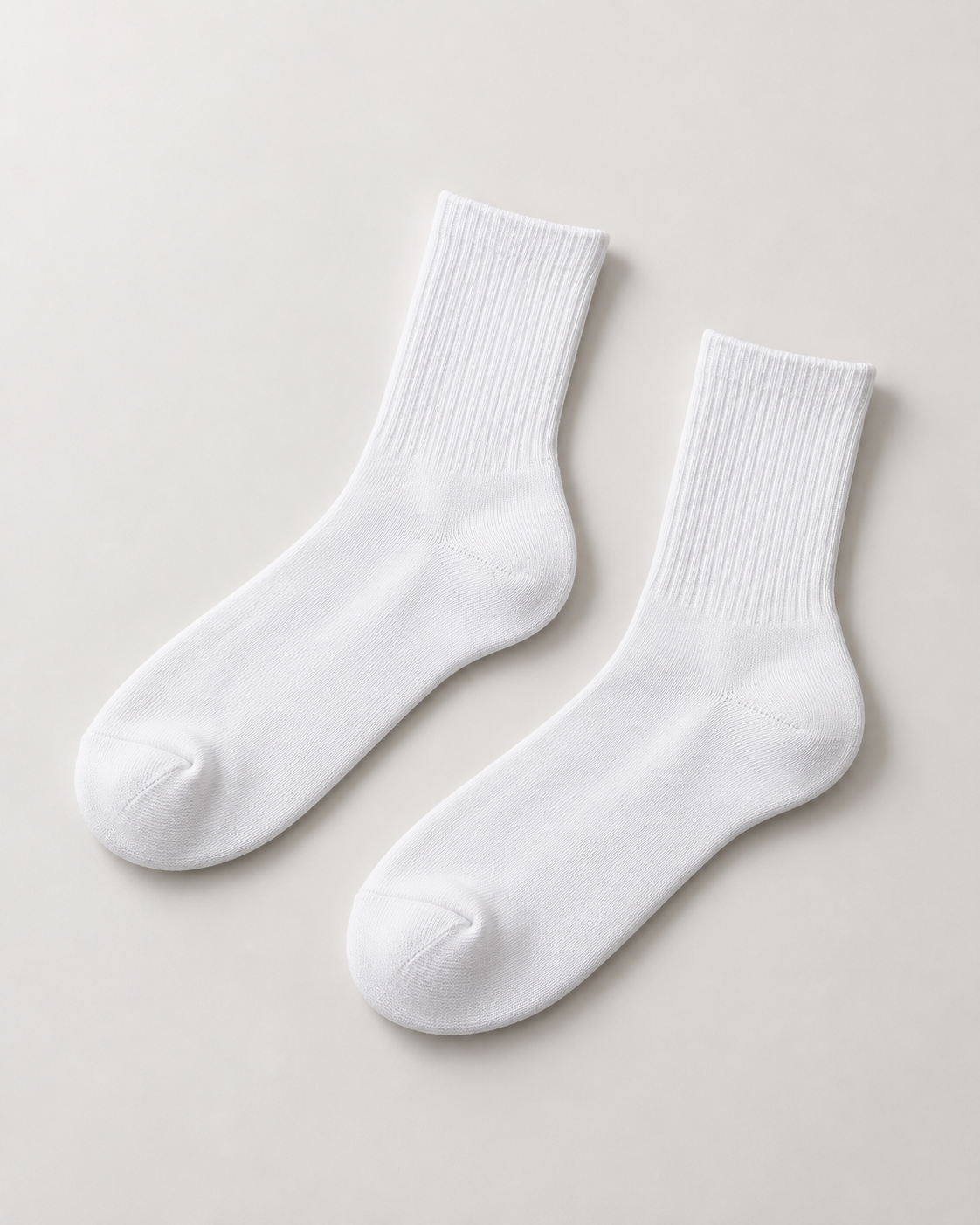 Concept mockup of a pair of white Akumi Balance Half-Crew Socks with mid-height ribbed shafts.