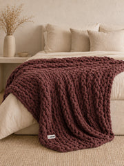 Akumi Emberloop Weighted Blanket Mulberry Clay bed styling view with sewn woven hem label
