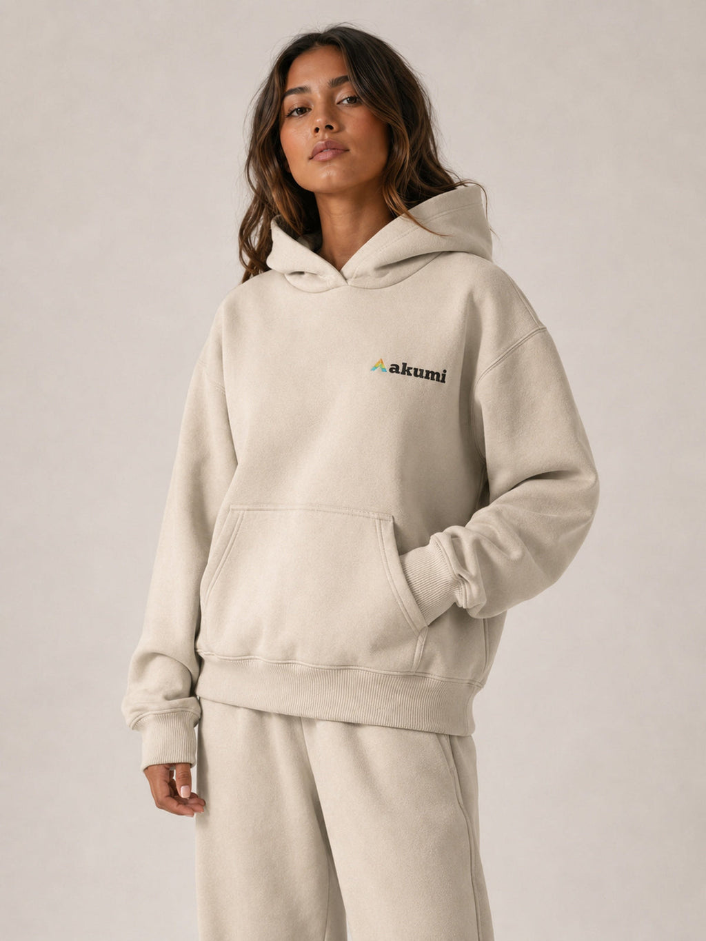 Akumi Essential Hoodie in Stone, upper body embroidered logo and pocket view