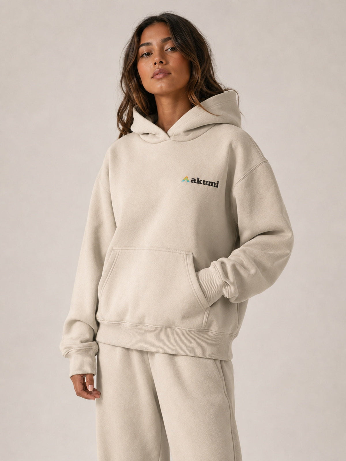 Akumi Essential Hoodie in Stone, upper body embroidered logo and pocket view