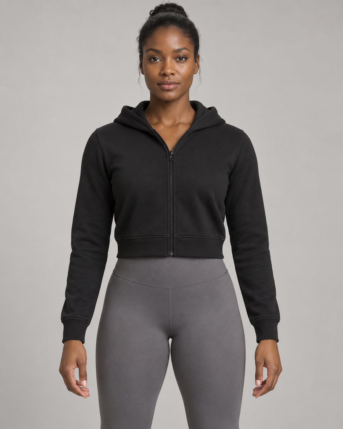 AI-generated design concept: woman wearing the proposed Formline Cropped Zip Hoodie in Onyx, front view.