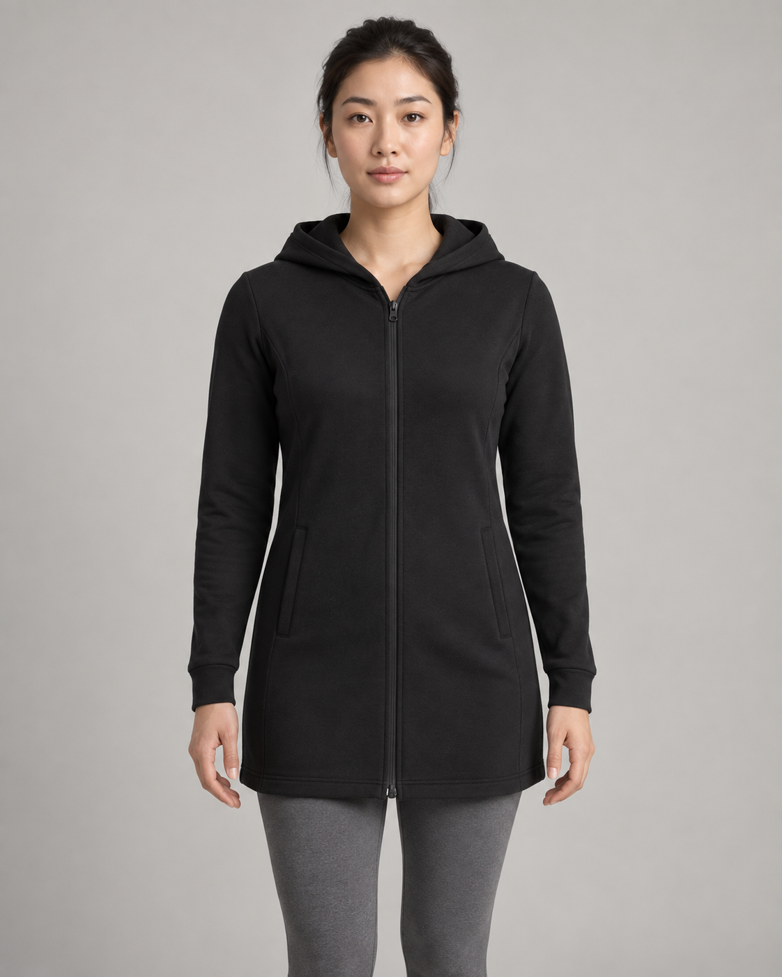 AI-generated design concept: woman wearing the proposed Formline Longline Zip Hoodie in Onyx, front view.
