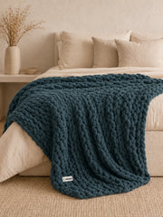 Akumi Groundloop Weighted Blanket Deep Harbor bed styling view with sewn woven hem label
