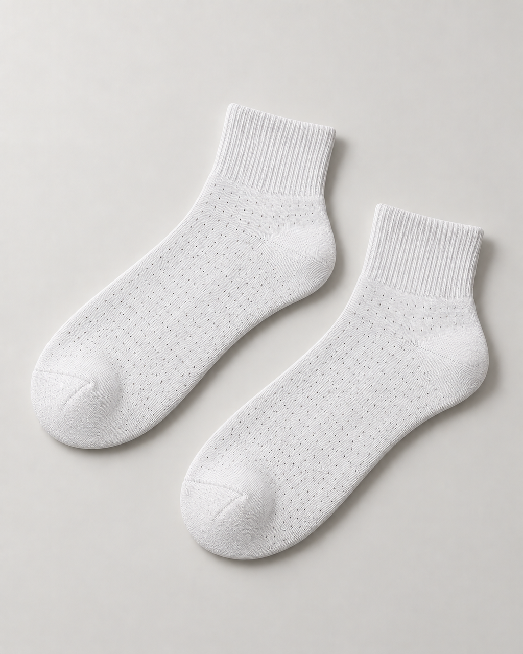 Concept mockup of a White Akumi Pinpoint Quarter Sock pair with a subtle dotted open-knit pattern.