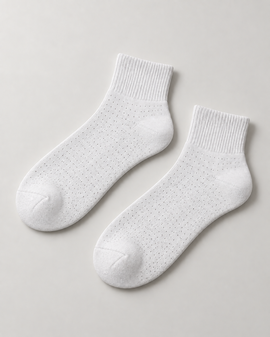 Concept mockup of a White Akumi Pinpoint Quarter Sock pair with a subtle dotted open-knit pattern.