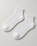 Concept mockup of a White Akumi Pinpoint Quarter Sock pair with a subtle dotted open-knit pattern.