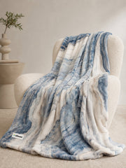 Akumi Shoreline Blanket in Mineral Tide draped over cream chair