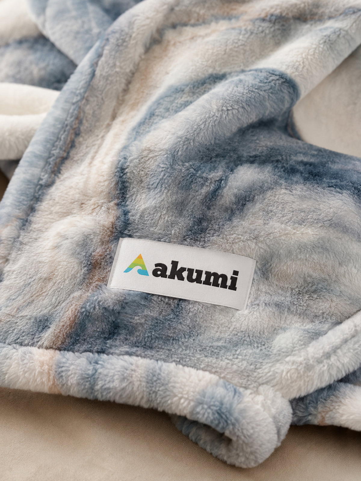 Close-up of Akumi Shoreline Blanket plush fabric and Akumi woven label