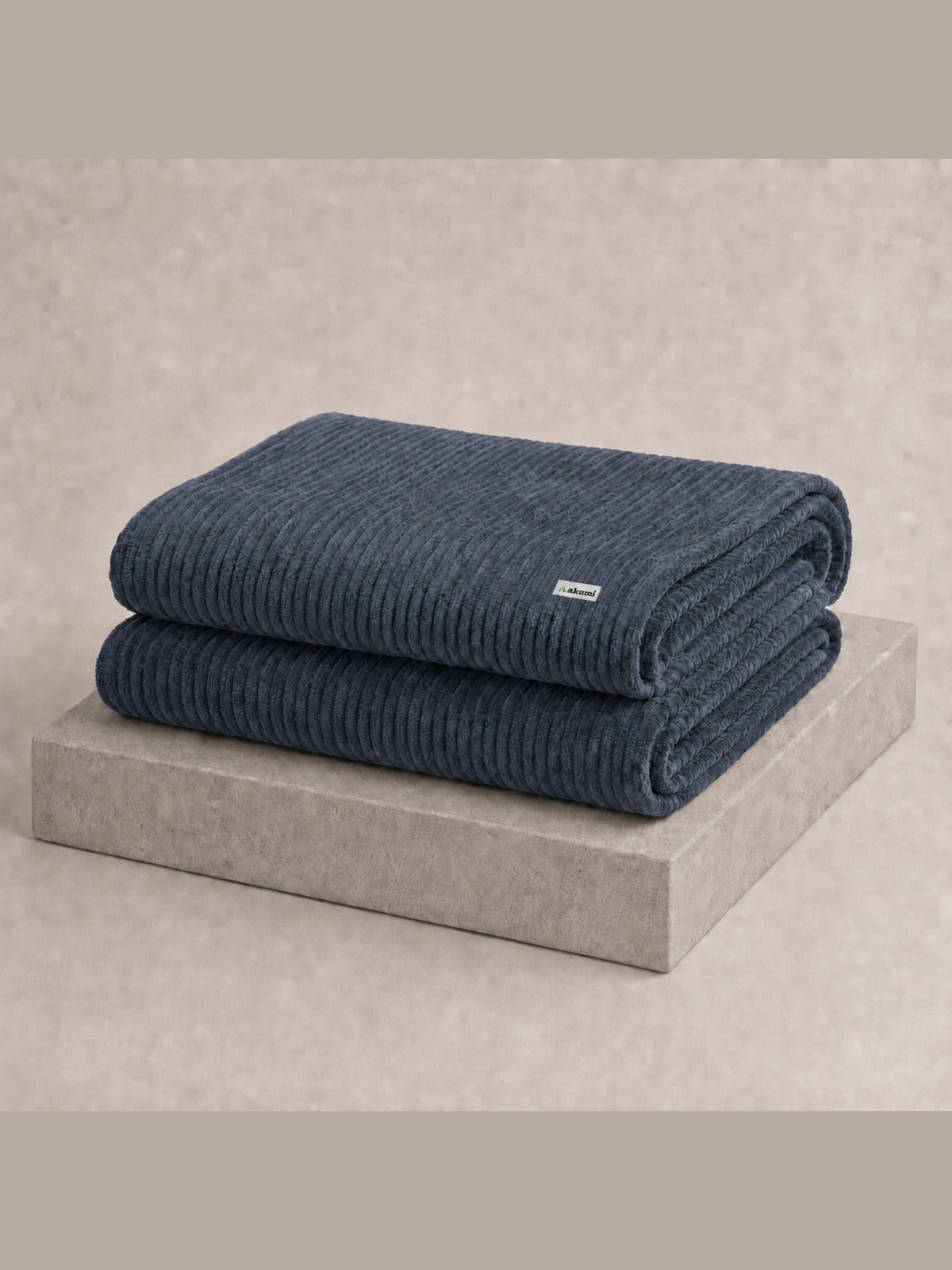 Akumi Still Blanket folded with consistent full-color Akumi woven label