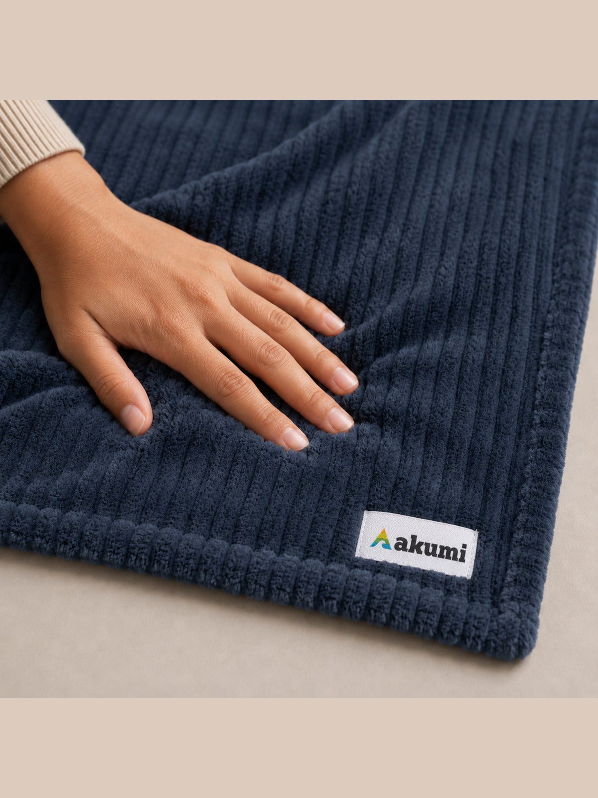 Close detail of Akumi Still Blanket plush rib texture and approved woven label