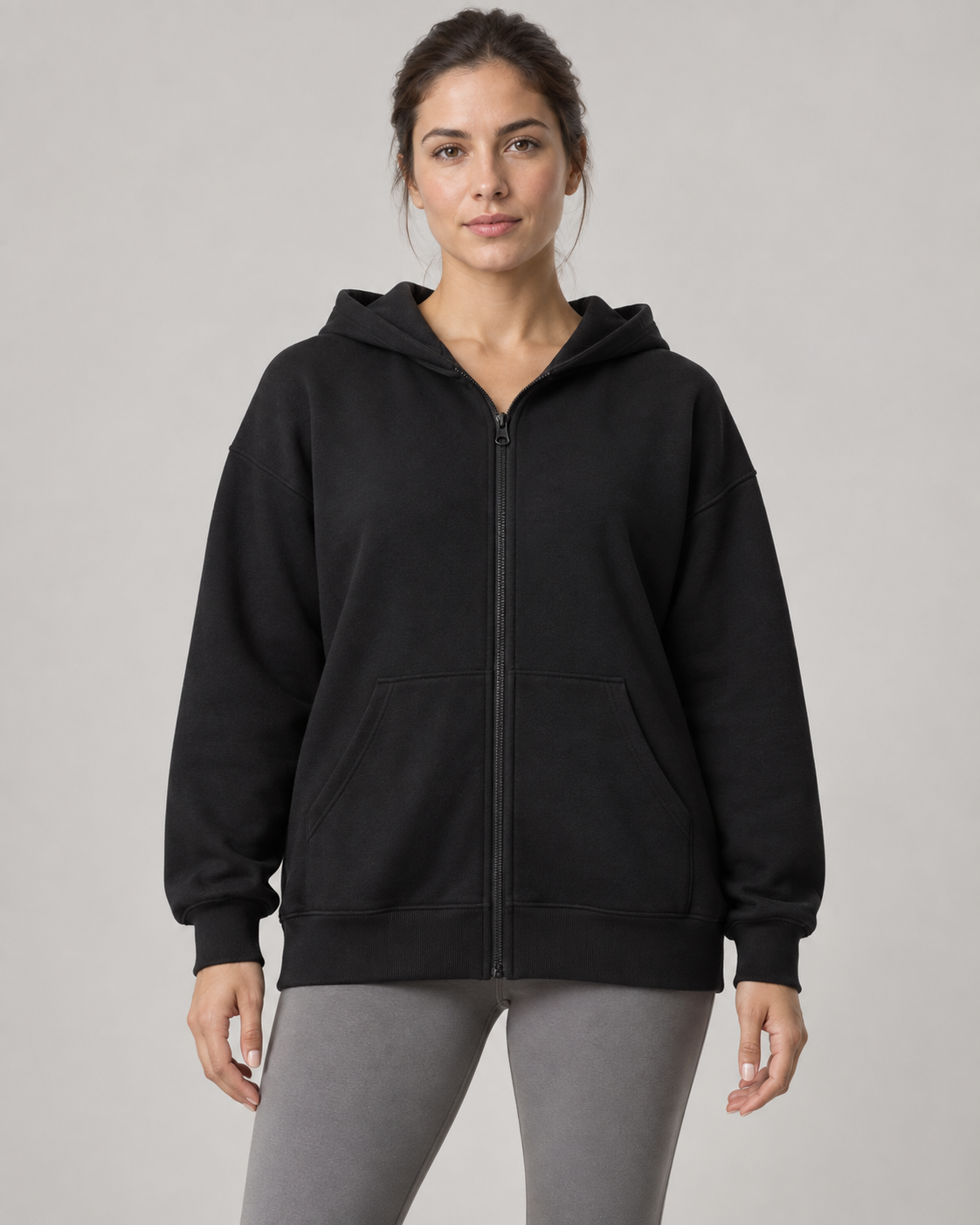 AI-generated design concept: woman wearing the proposed Stillform Full-Zip Hoodie in Onyx, front view.