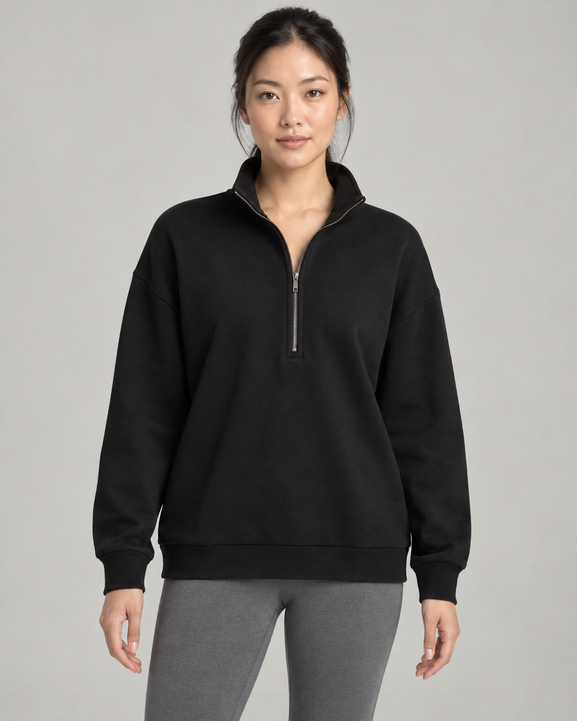 AI-generated design concept: woman wearing the proposed Stillform Half-Zip Sweatshirt in Onyx, front view.