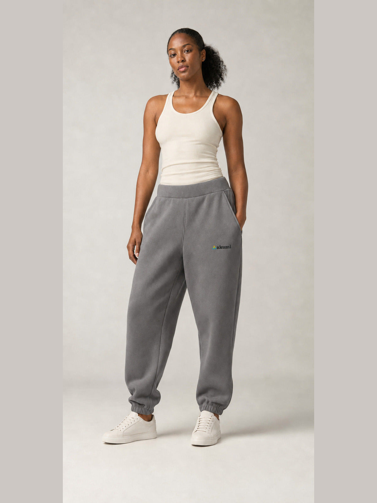 Akumi Stillform Sweatpant in Mineral Grey with full Akumi logo, front three-quarter view