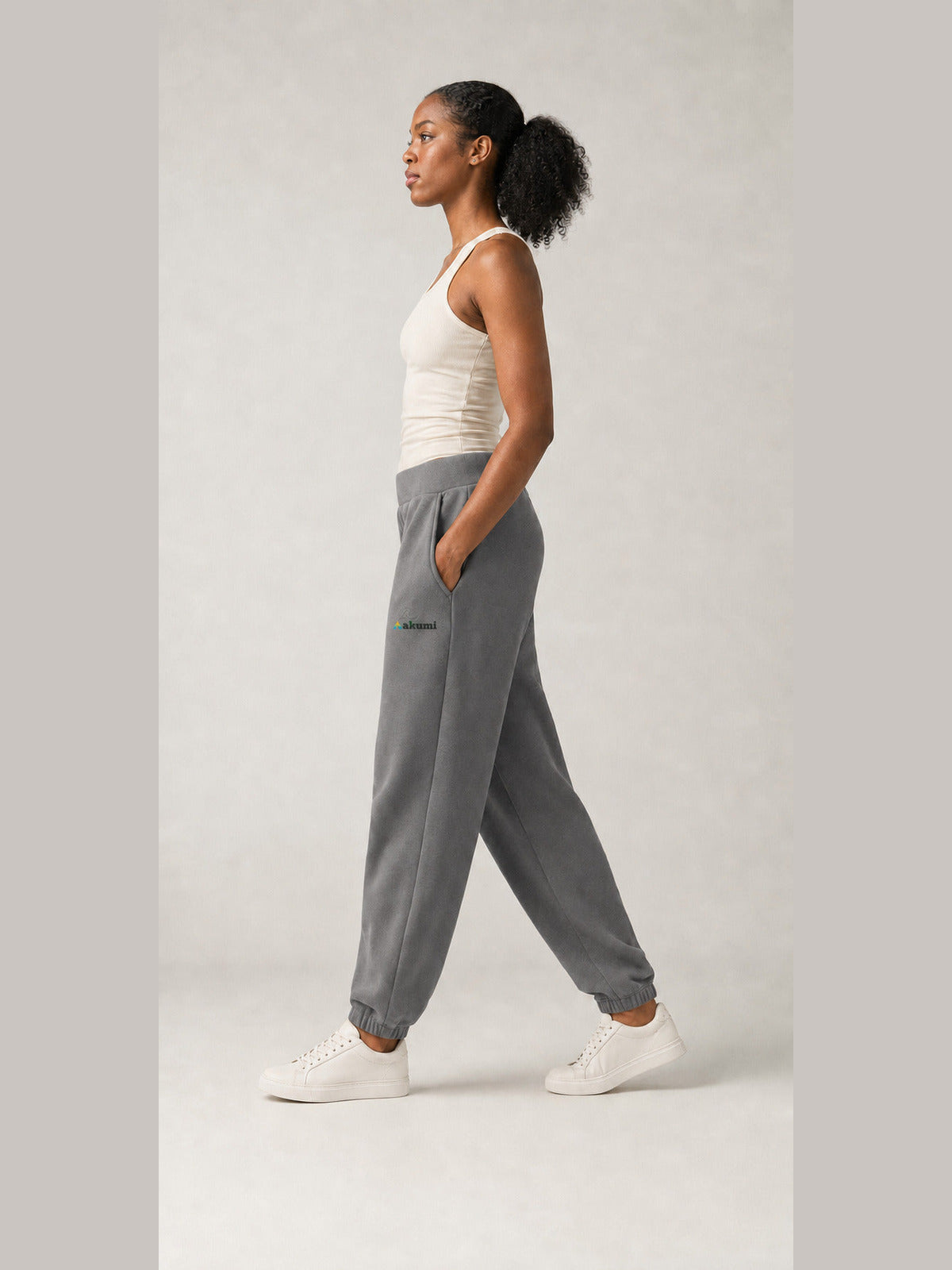 Akumi Stillform Sweatpant in Mineral Grey with full Akumi logo, side walking view
