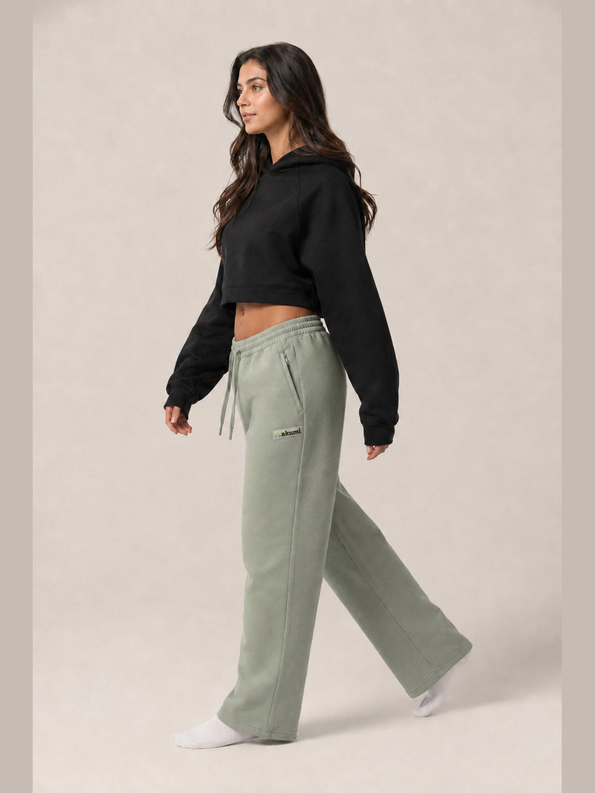Akumi Transitline Straight-Leg Travel Sweatpant in Sage Fog, cleaned Akumi logo, side walking view with zip pocket
