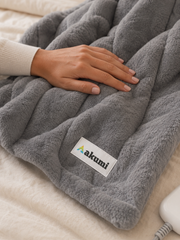 Close detail of Akumi Warmline Blanket plush texture and woven label