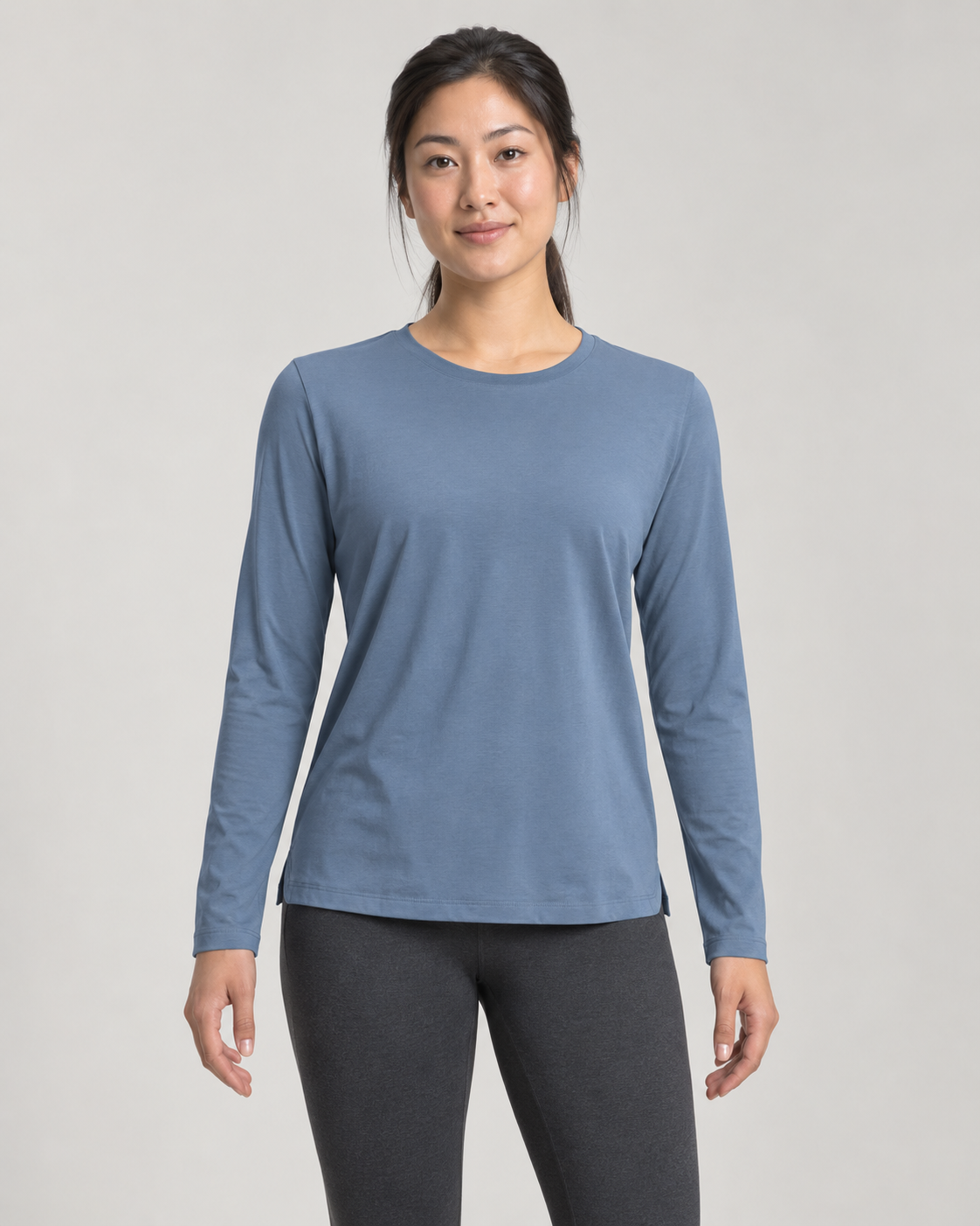 Concept mockup: Akumi Reset Long Sleeve Crew in Slate Blue, front view on an adult woman.