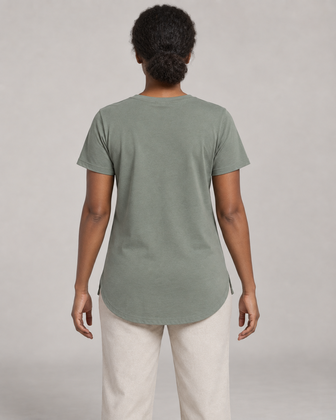 Generated concept mockup: women's Dayform Longline Tee in Eucalyptus, back view on model.