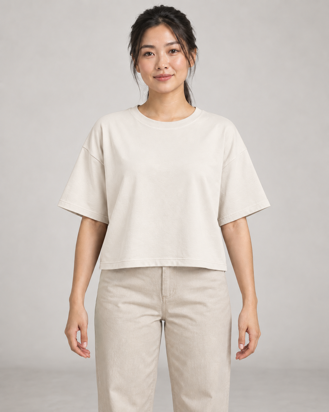 Generated concept mockup: Women's Still Box Tee in Chalk, front view on model.