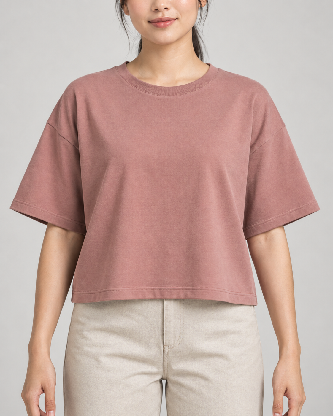 Generated concept mockup: Women's Still Box Tee in Dusty Rose, construction detail view highlighting dropped shoulder seam, wide sleeve and straight boxy hem.