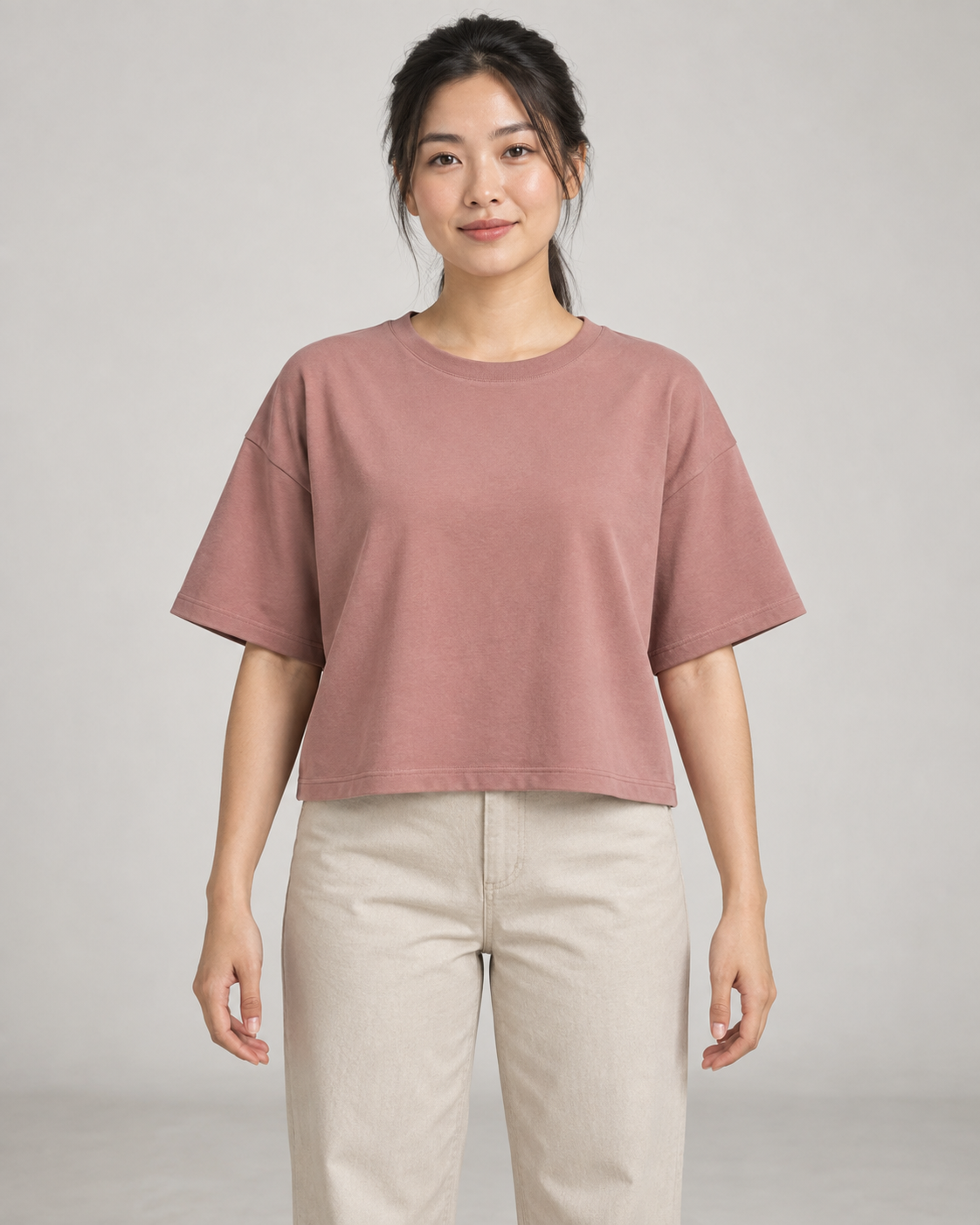 Generated concept mockup: women's Still Box Tee in Dusty Rose, front view on model.