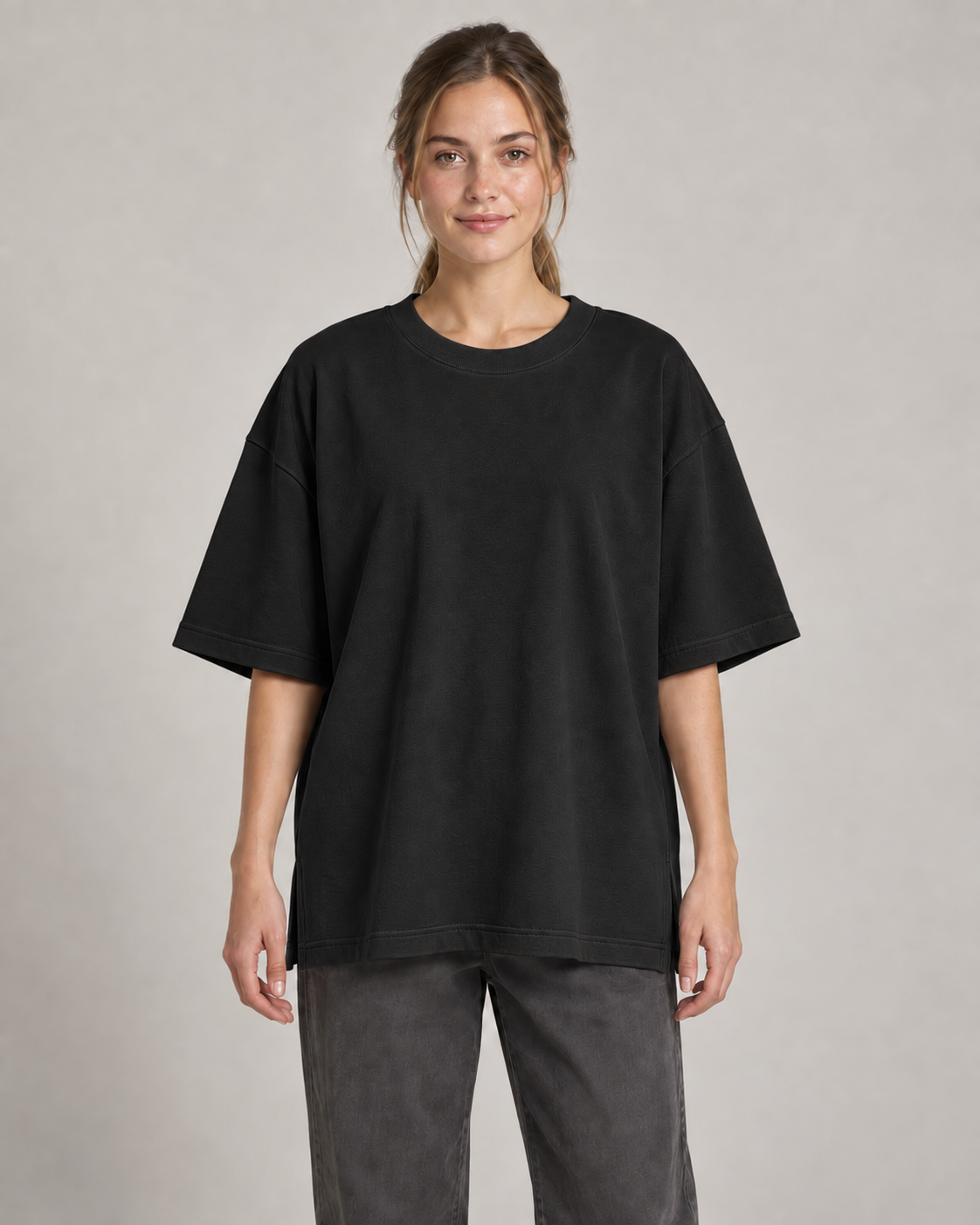 Generated concept mockup: Women's Still Oversized Tee in Black, front view on model.