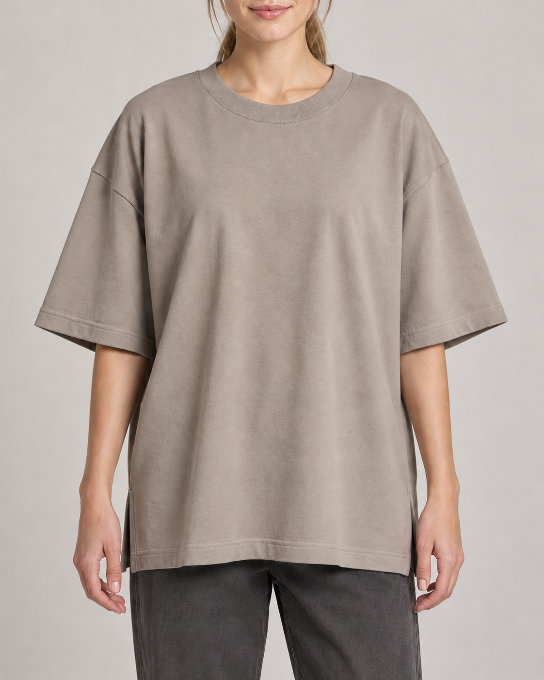 Generated concept mockup: Women's Still Oversized Tee in Stone, construction detail view highlighting crew neckline, dropped shoulder construction, wide sleeve and relaxed straight hem.