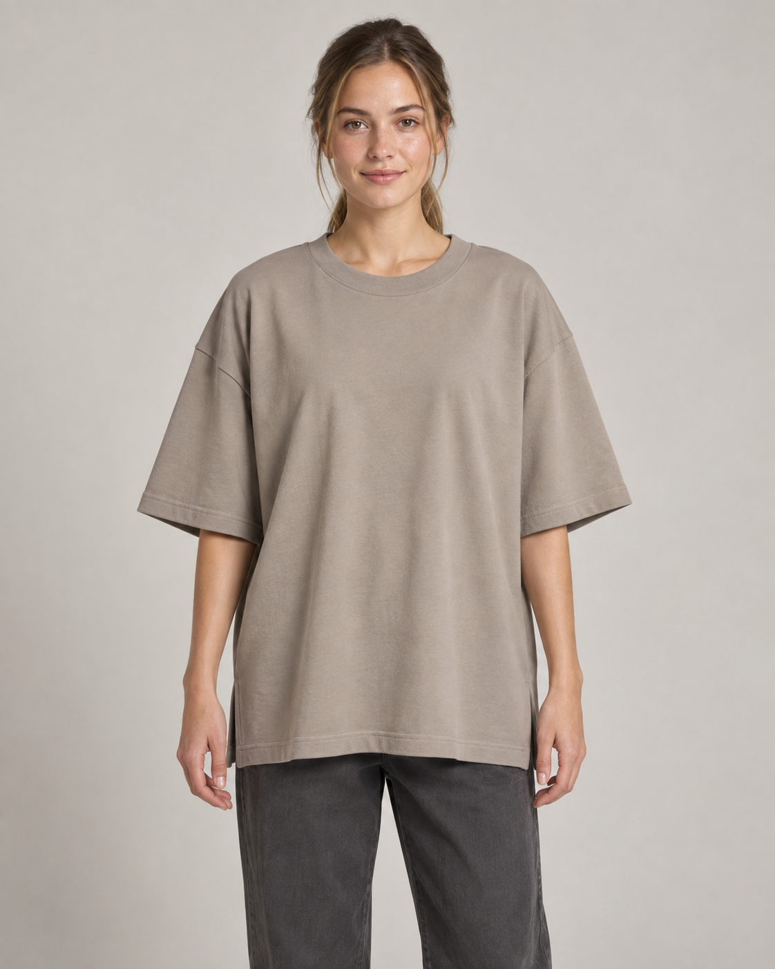 Generated concept mockup: women's Still Oversized Tee in Stone, front view on model.