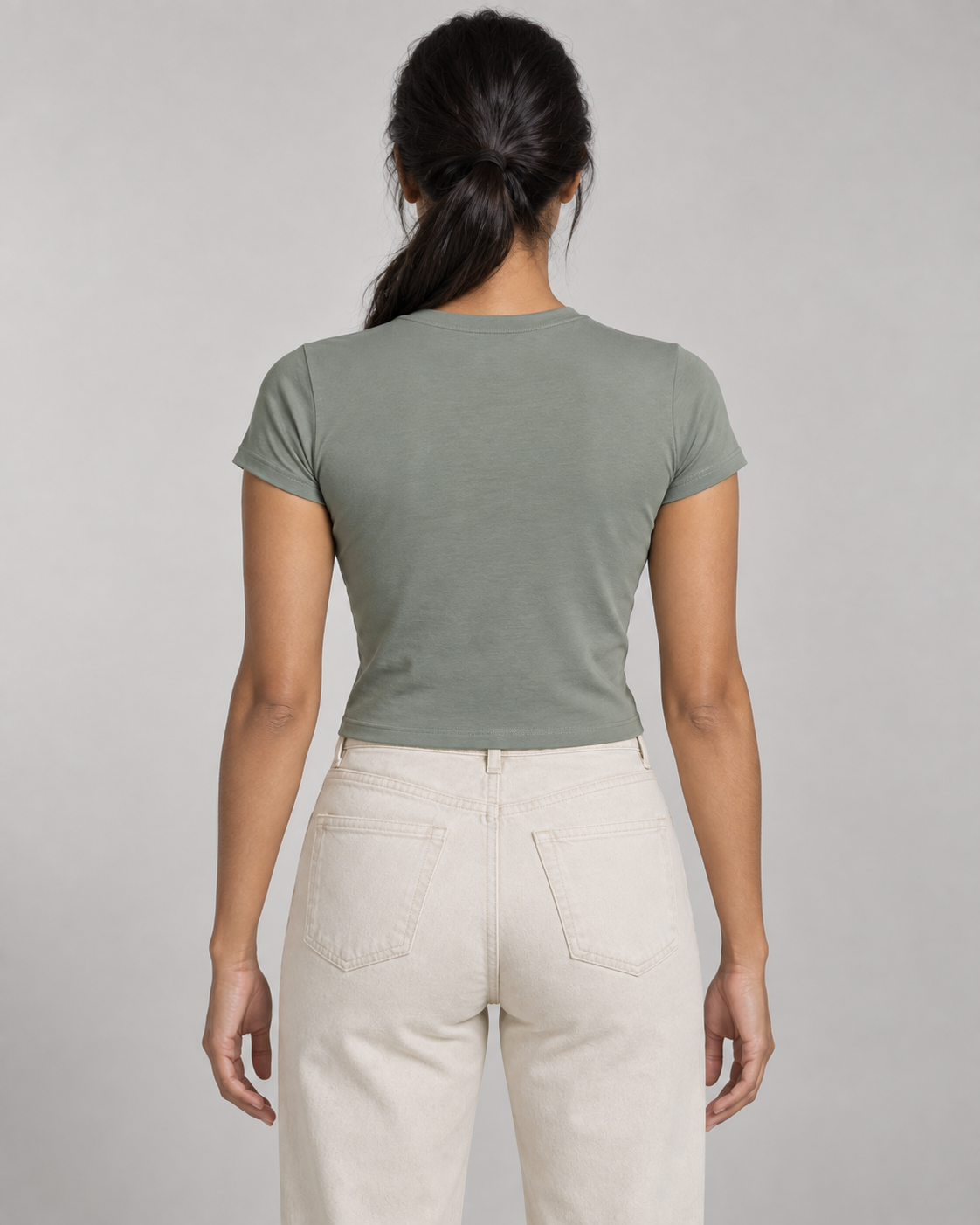Generated concept mockup: women's Balance Baby Tee in Eucalyptus, back view on model.