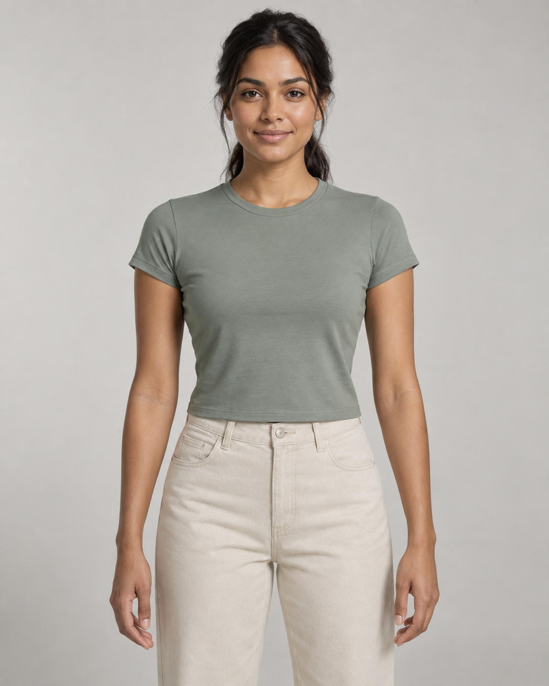 Generated concept mockup: women's Balance Baby Tee in Eucalyptus, front view on model.