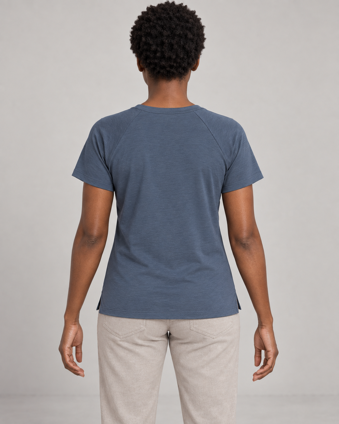 Generated concept mockup: women's Cadence Raglan Tee in Slate, back view on model.