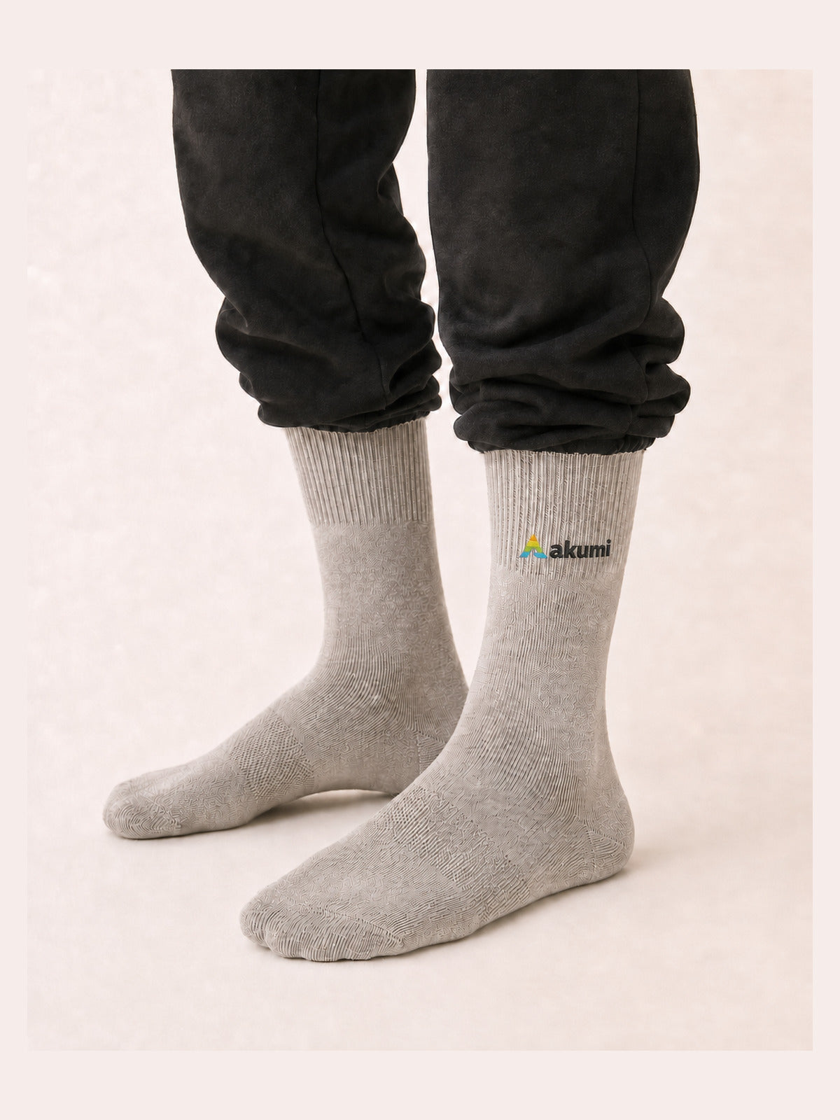 Akumi Balance Mid-Crew Sock in Mineral with corrected raised embroidered Akumi wave logo, worn studio view